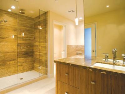 Frameless Front Only Shower Screen in a warm lighted bathroom with brown cabinet and tile