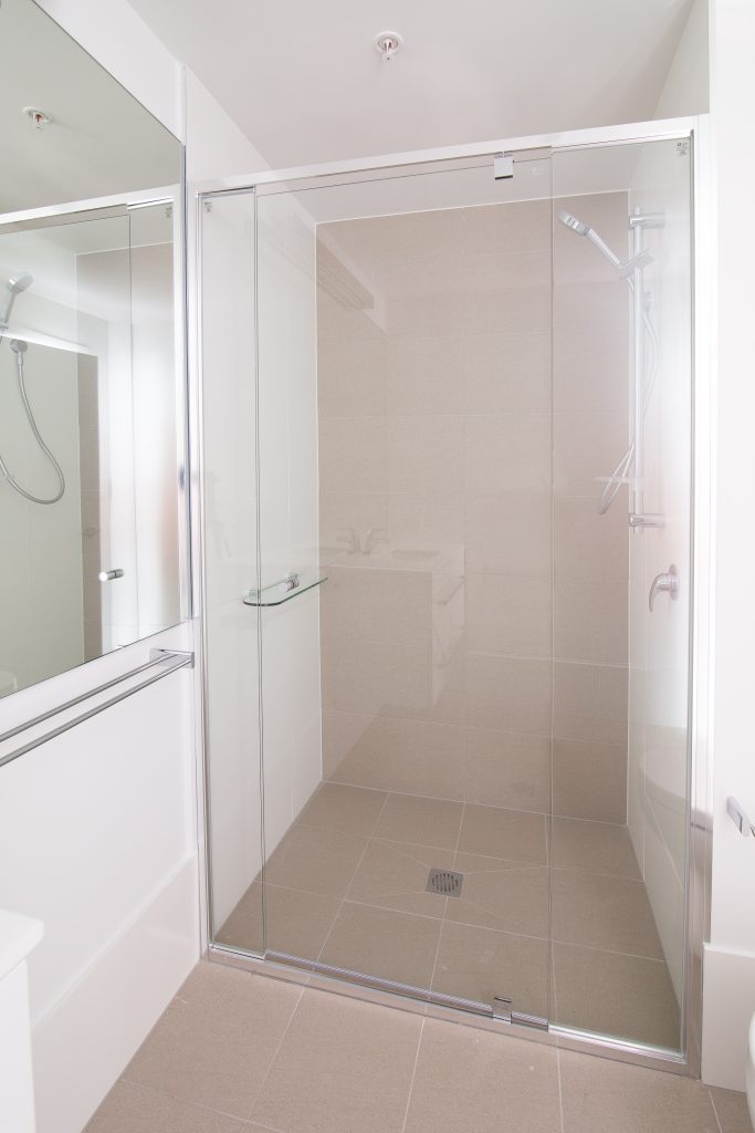 polished silver aluminium framed showerscreen, 4mm, safety glass. polished silver hinges and door handles.