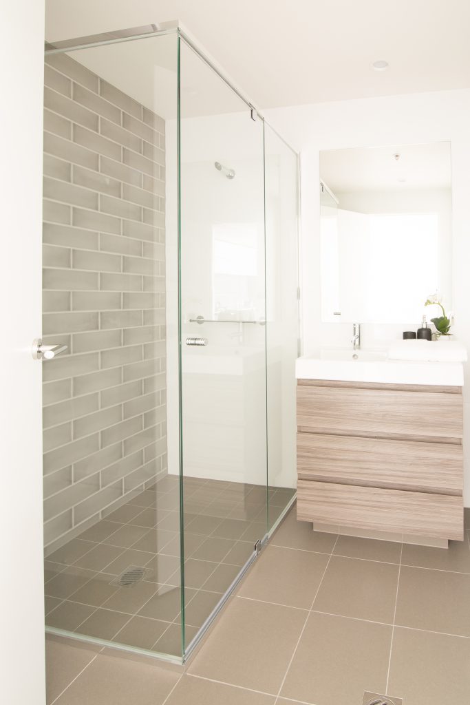Polished silver aluminium framed showerscreen, 4mm safety glass. polished silver hinges and door handles.