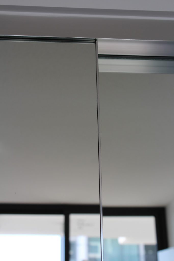 Frameless Mirrorline Robe Door in Silver Aluminium Track Top Close-up View