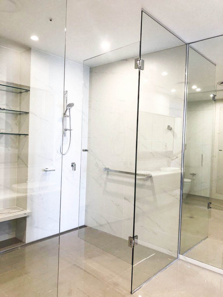 Frameless Hinged shower T screen on white bathroom with shelves and shower