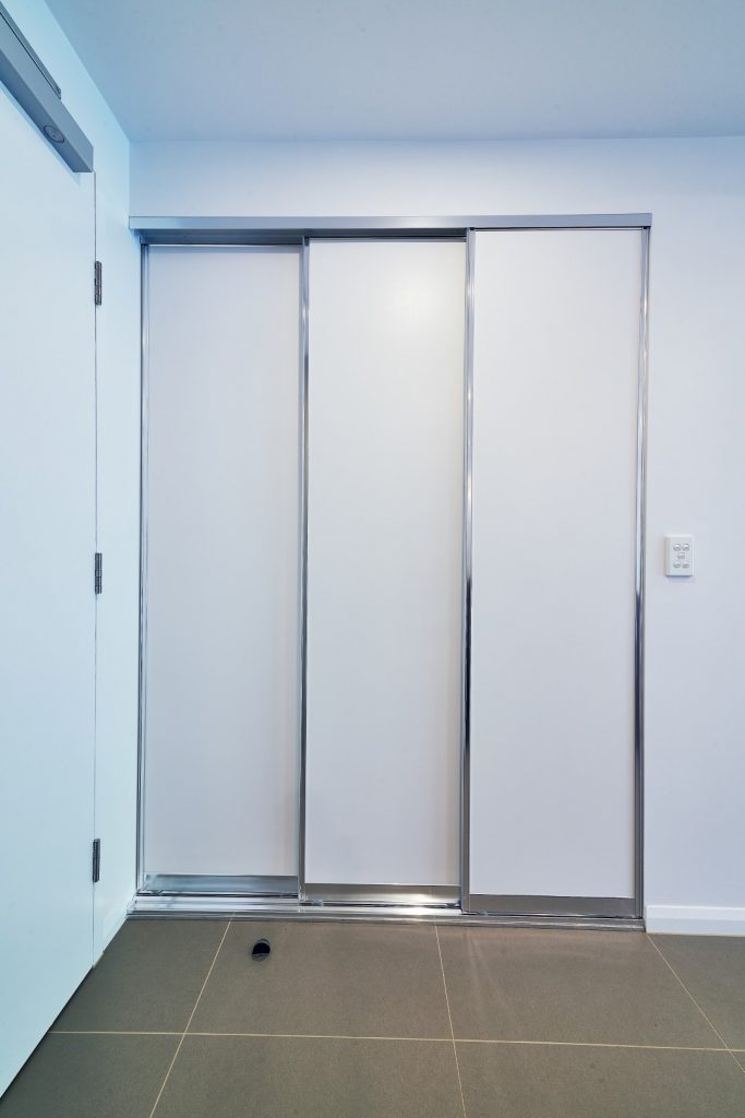 Slimline Robe Doors with Three Panels in front Laundry Compartment with Silver Aluminium Frame