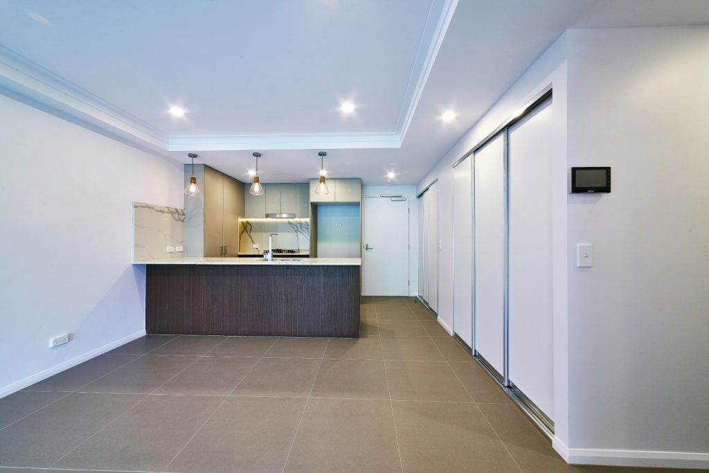 Slimline Hallway Robe Doors with Silver Aluminium Frames in front of wide Kitchen Area