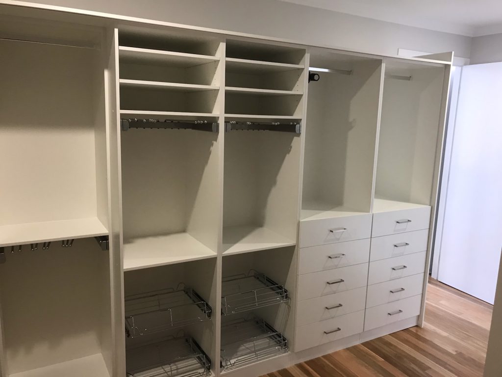 Built-In Wardrobe - White Board Shelving, Banks of Drawers with Polished Silver Handles, Sliding Storage Drawers & Chrome Hanging Rods