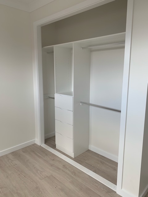 Built-In Wardrobe - White Board Shelving with a Bank of Shelves & Chrome Hanging Rods