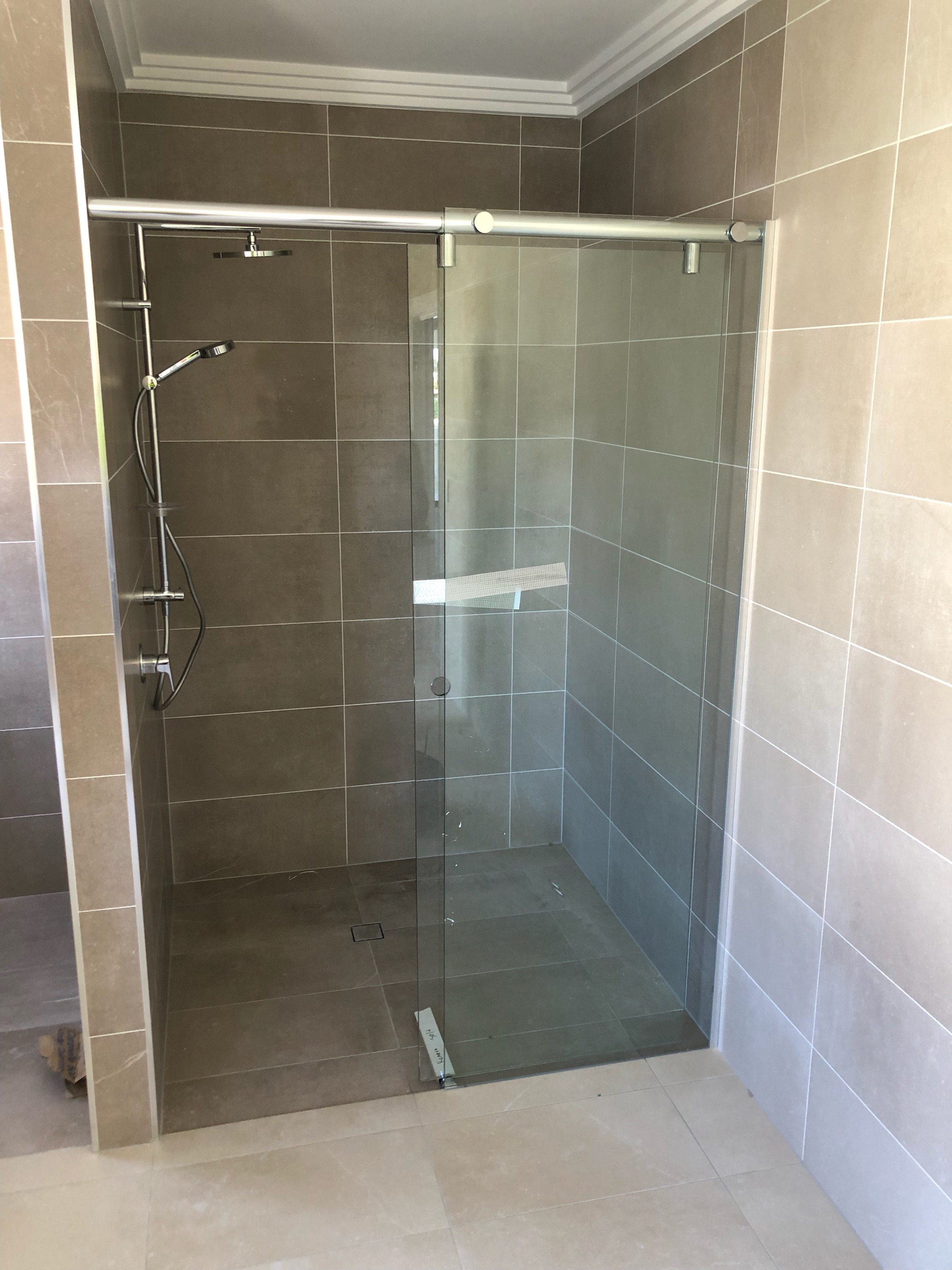 Frameless Sliding Shower Screen in a bathroom beeing constructed