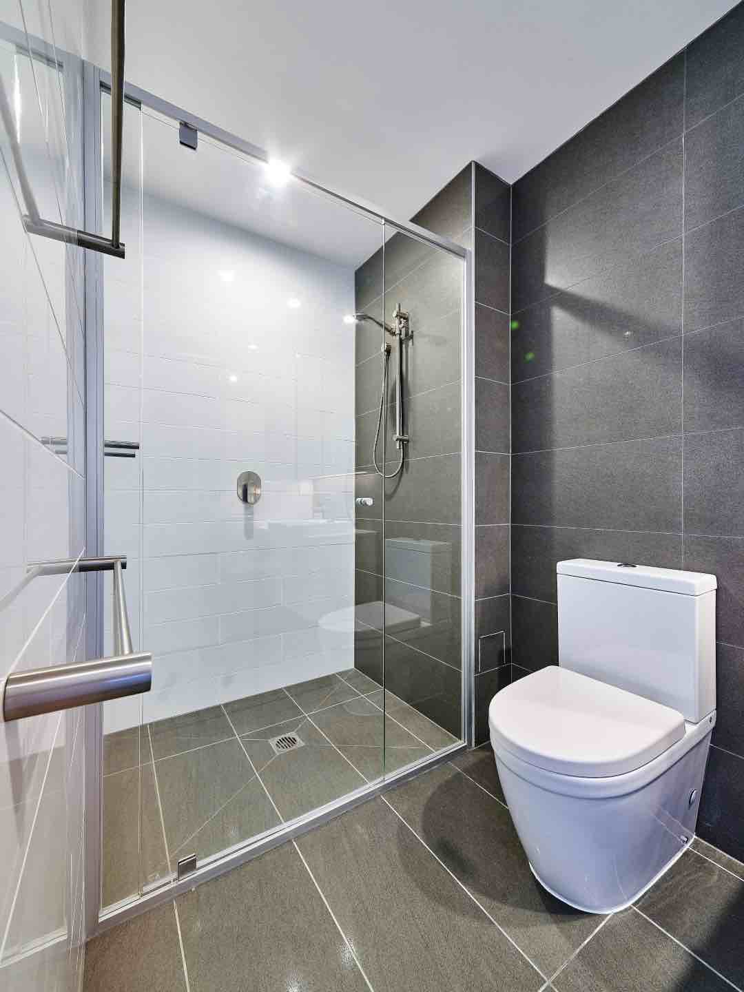Vogue Semi Frameless Shower Screen Installed In Grey Tiled Bathroom