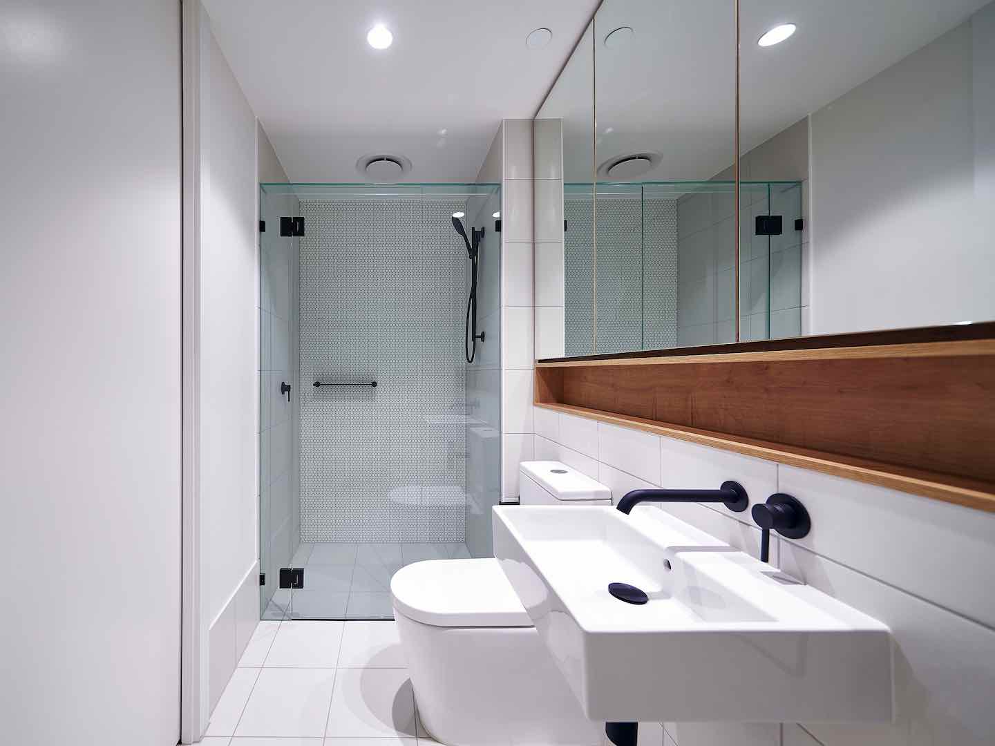 Frameless Hinged shower screen on white bathroom and toilet