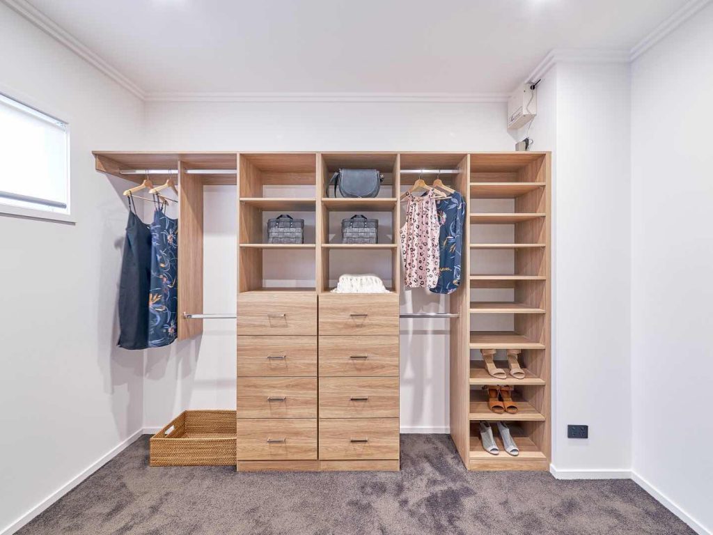 Nordic Oak Walk-in wardrobe shelving with garment compartments and chrome hanging rails and multiple shelves and drawers with silver handles
