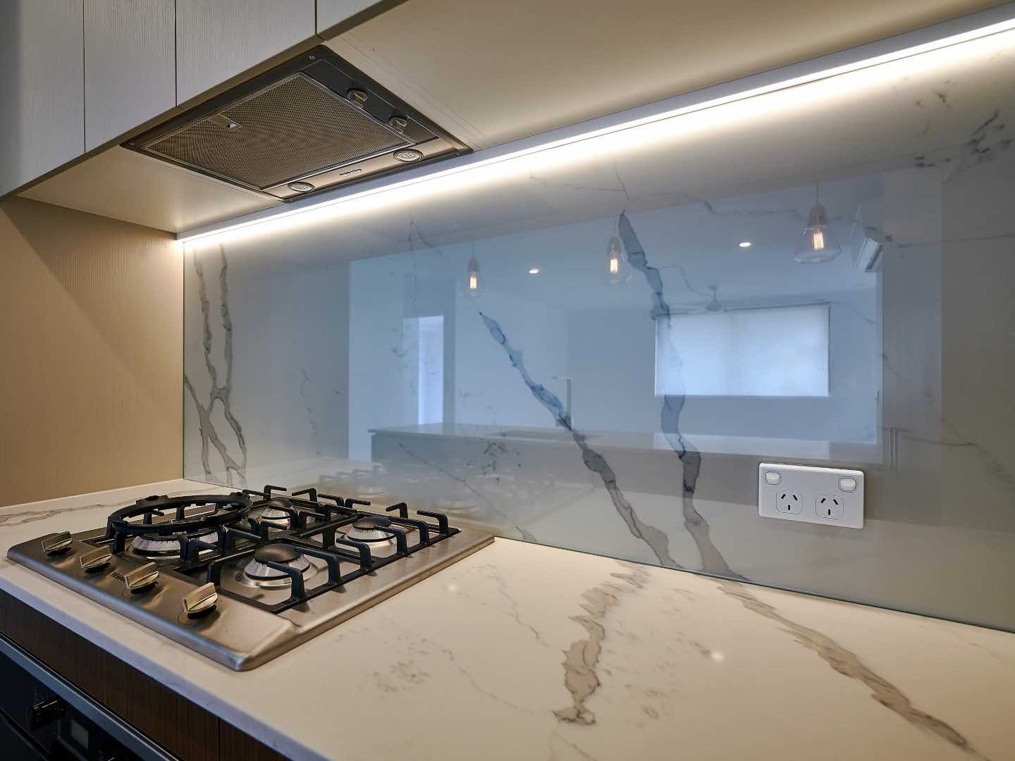 Clear Low Iron Glass Splashback with marble design installed over stone behind cooktop with stove