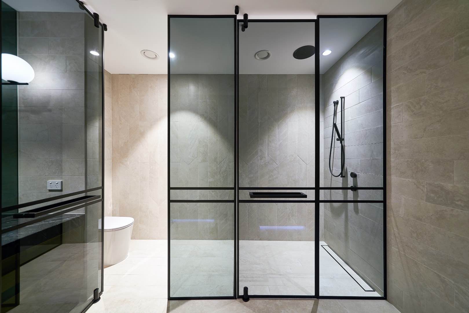 Grey Shower Screen With Pivot Door with seperate toilet and bath. With bathtub and clean tiled interior.