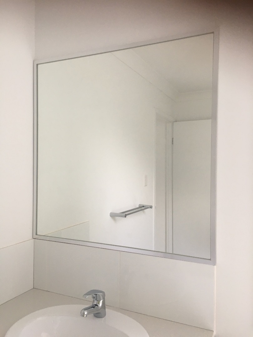 Fully Framed Mirror on white tiles with white vanity