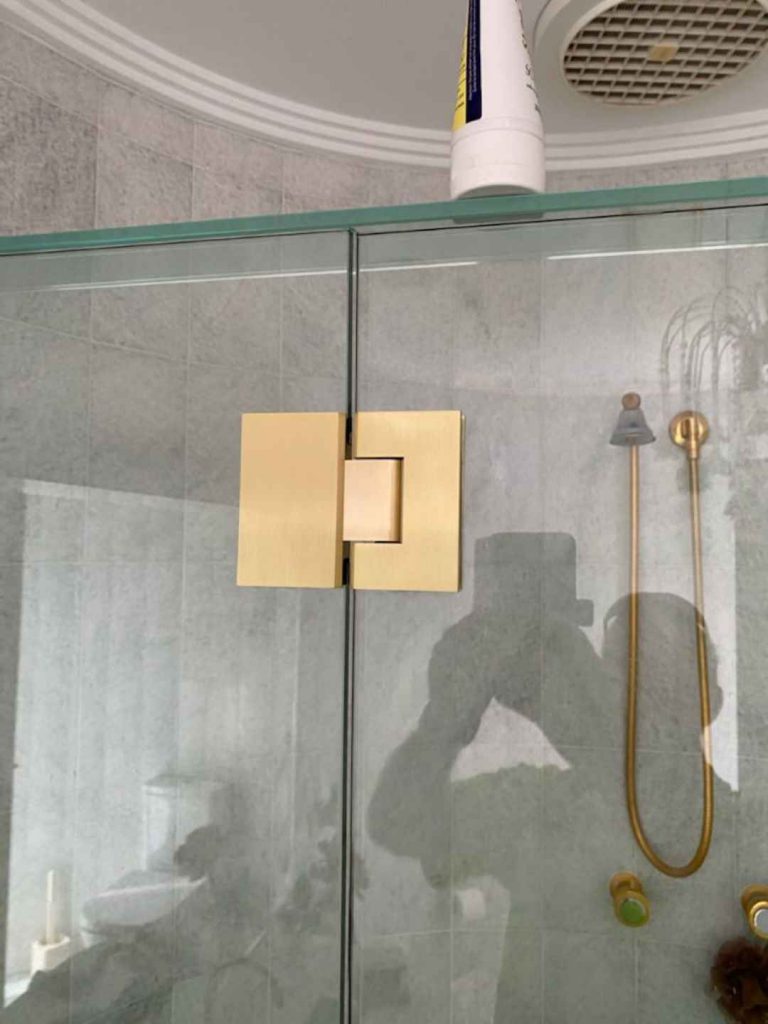 Frameless shower screen with luxurious gold polished hinges and accessories