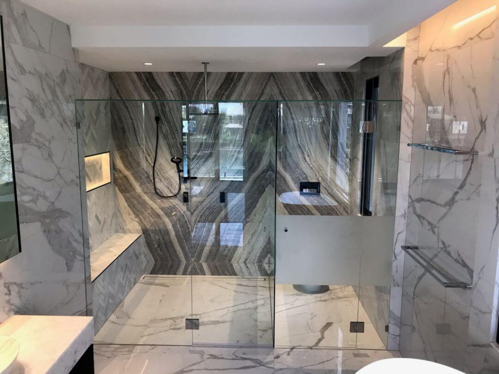 Frameless T screen on luxurious modern bathroom separating toilet from bath