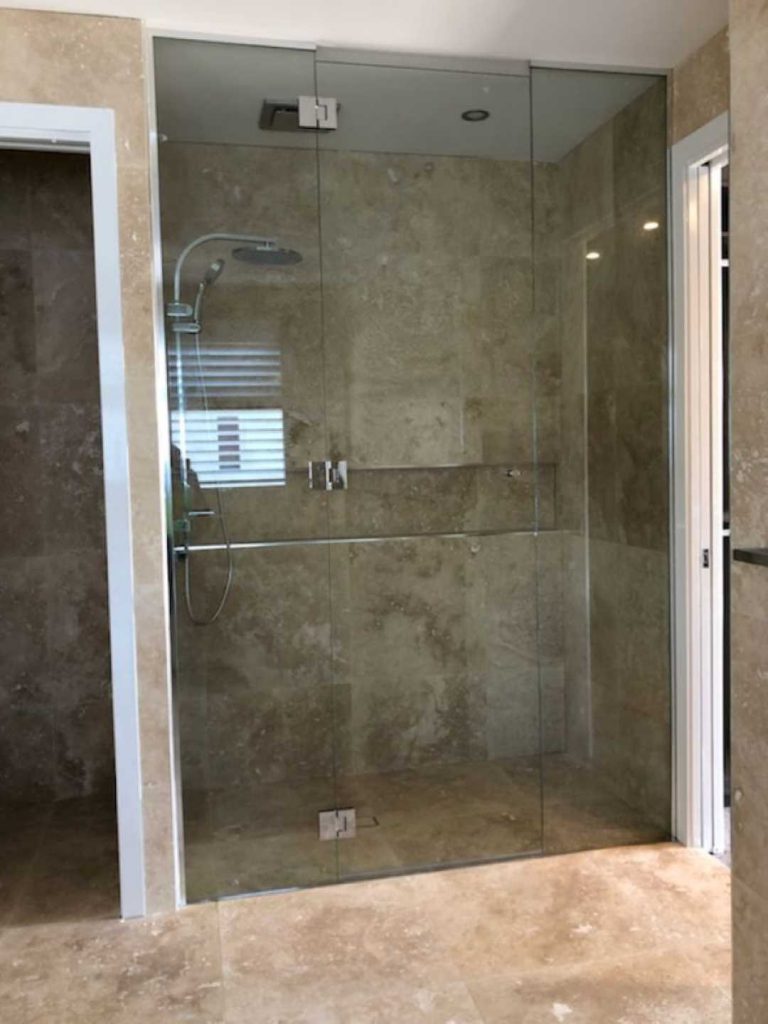 Frameless Hinged Shower Screen closed on classy granite bath