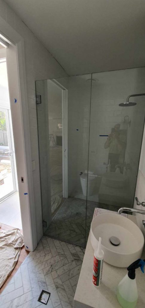 Frameless Hinged Shower Screen on a bathroom being constructed
